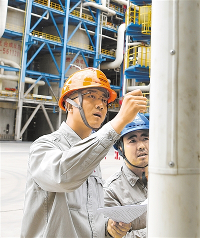 国家能源集团宁夏煤业有限责任公司年产400万吨煤炭间接液化项目现场，周龙（左）同其团队人员检查设备运行情况。