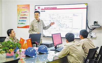 周龙（中）与团队人员召开技术交底培训会。