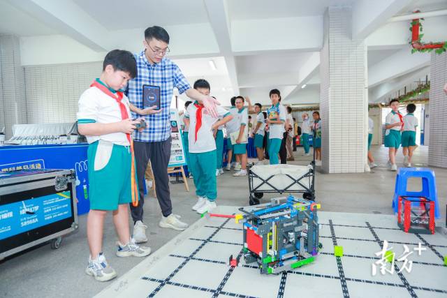同学们在科普集市上乐享区内企业的机器人配合赛体验项目。受访单位供图