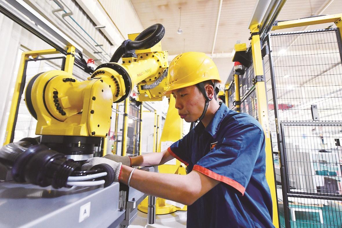 宁夏巨能机器人股份有限公司工人在调试“关节机器人”。